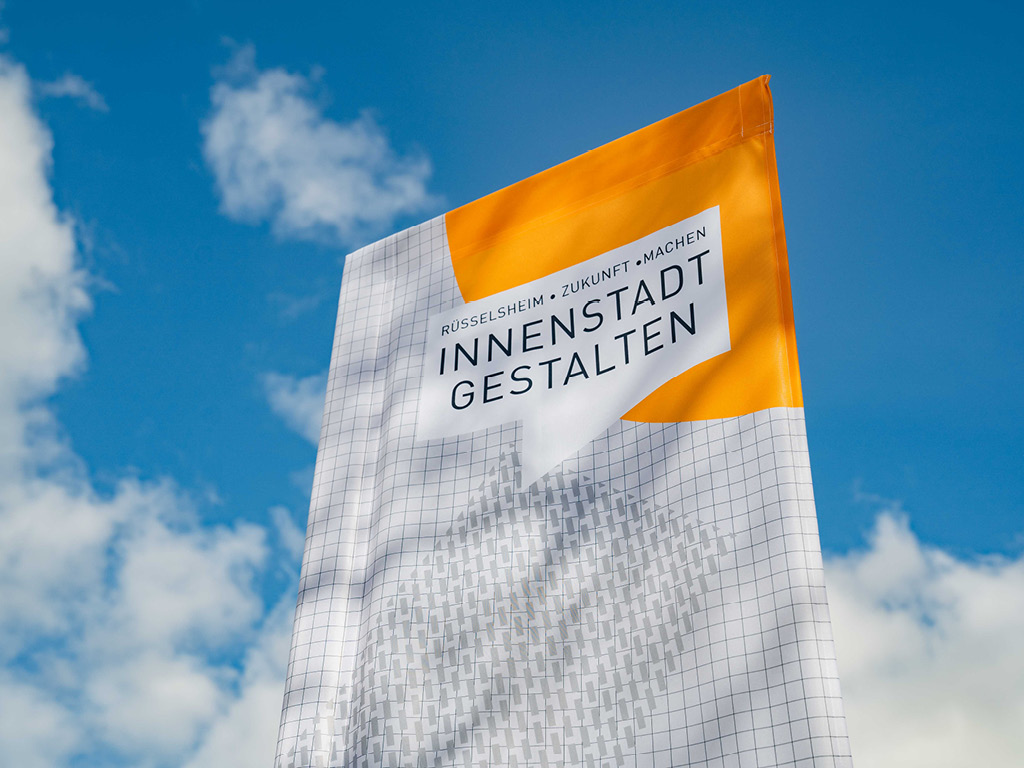 Eine Flagge mit dem Logo des Prozesses vor blauem Himmel