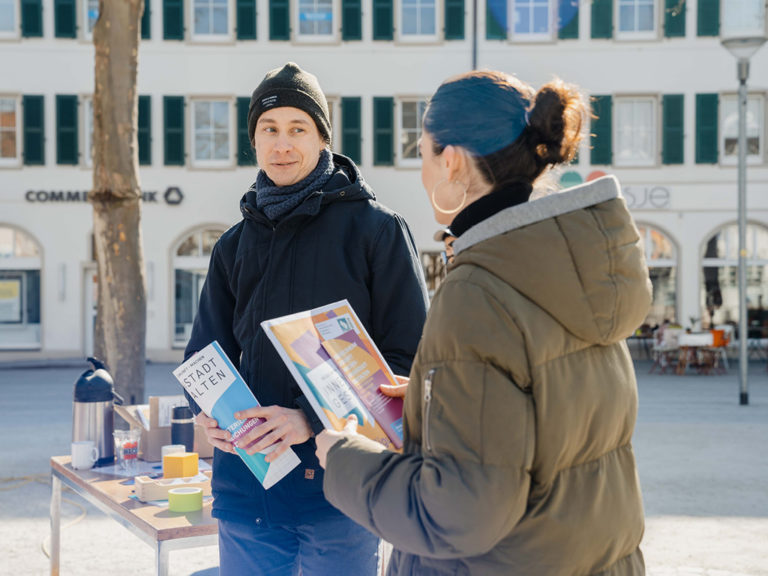 Ein Mitarbeiter des Projektteams im Gespräch mit einer Bürgerin